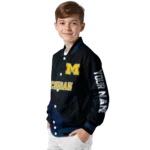 personalized-michigan-wolverines-hexagon-mesh-blue-black-varsity-jacket-best-selling.webp